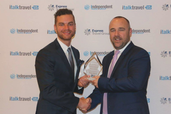 RoundAbout Travel Director Mark Trim accepting the Diamond Award in recognition of excellence.