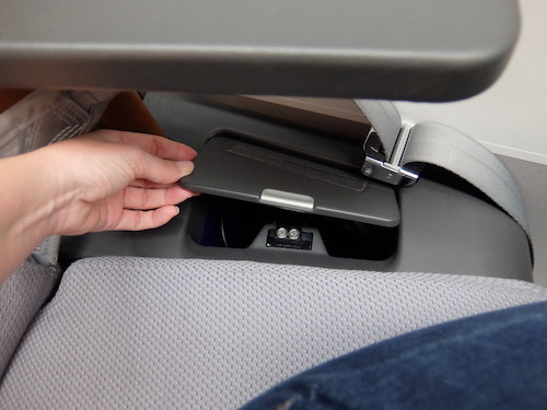 Noise cancelling headphones tucked into the arm rest.
