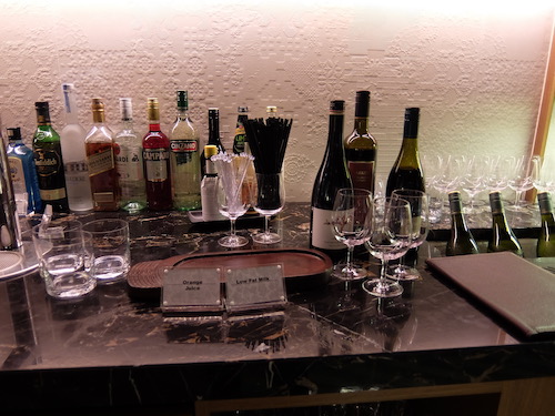 the bar is fully stocked with a range of spirits.