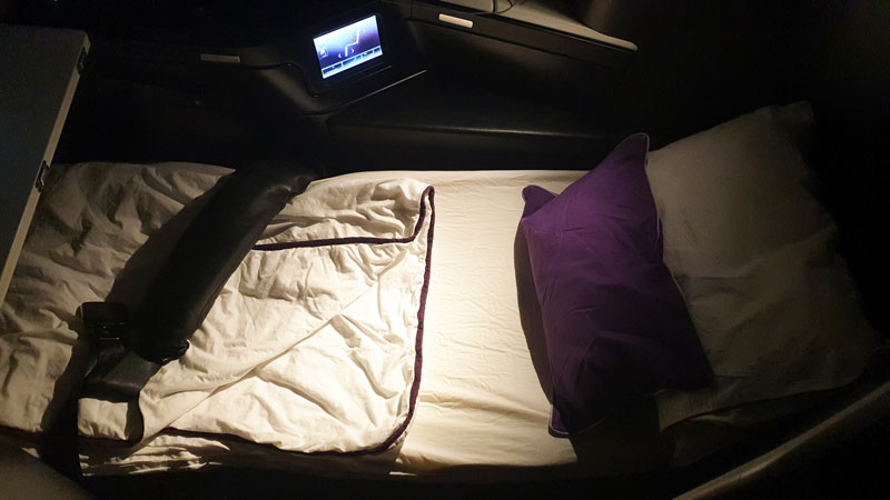 The Business fully flat bed with mattress top, and plush bedding